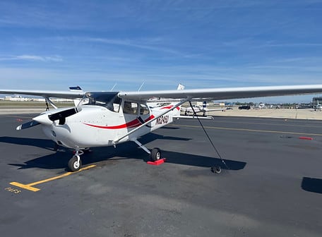 Cessna 172N N6245D, white with a red stripe, tied down on the ramp